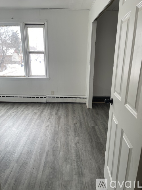 A room with a window and wooden flooring.