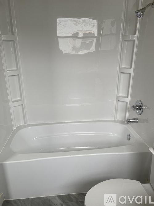 A white bathroom with a tub, toilet and shower.