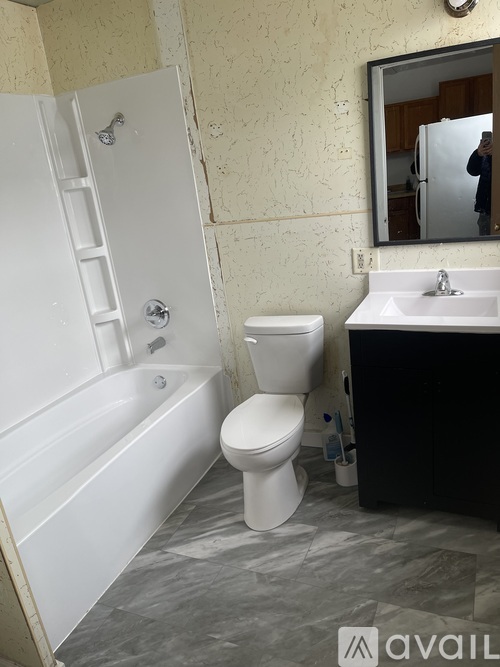 A bathroom with a white toilet, sink, and bathtub.