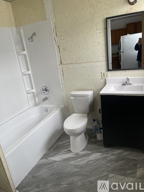 A bathroom with a white toilet, sink, and bathtub.