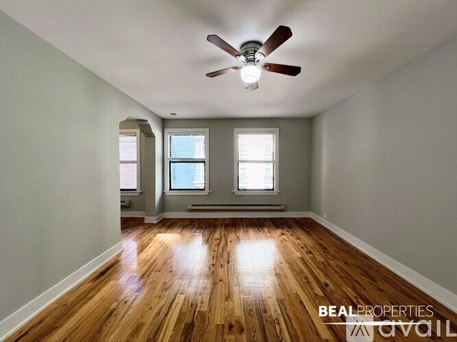 A room with wooden floors and a ceiling fan.