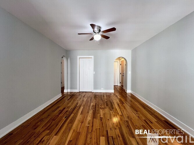 A room with wooden floors and a ceiling fan.