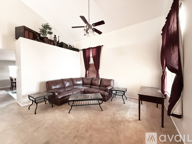 A living room with a brown leather sofa and a black metal coffee table.