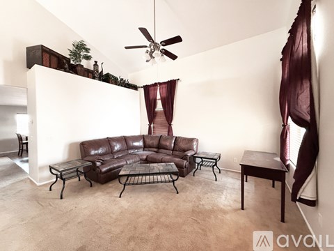 A living room with a brown leather sofa and a black metal coffee table.