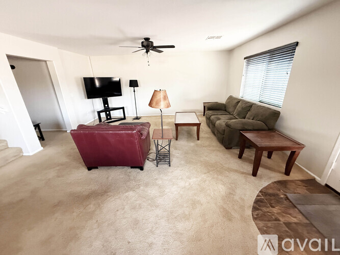A living room with a couch, chair, and television.