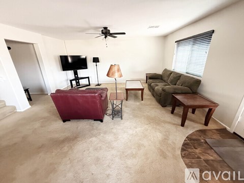 A living room with a couch, chair, and television.