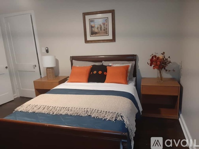 A bedroom with a bed, nightstands, and a framed picture on the wall.