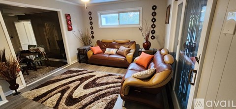 A living room with a brown couch and a zebra rug.