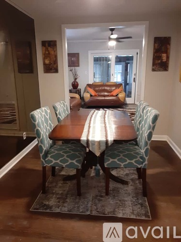 A dining room with a wooden table and chairs.
