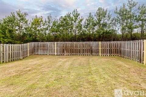 A backyard with a wooden fence and grass.