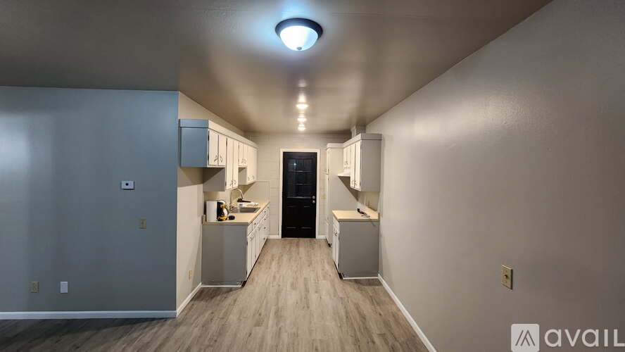 A long, narrow hallway with a kitchen area at the end.