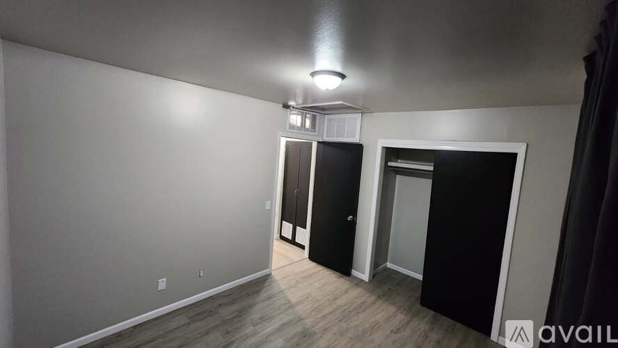 A room with a white wall and a black door.