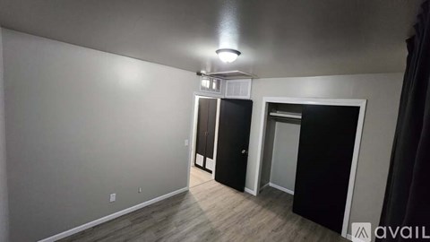 A room with a white wall and a black door.