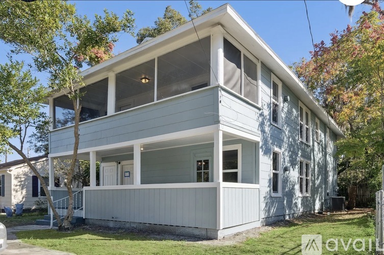 A two-story house with a white exterior and a balcony on the second floor.