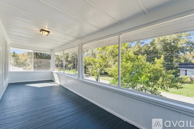 A sunny day in a room with a long wooden floor and a large window.