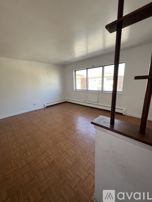 A room with wooden flooring and a window.