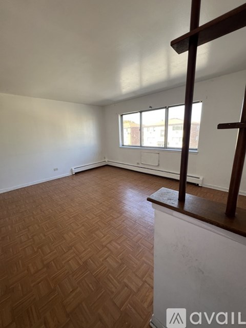 A room with wooden flooring and a window.