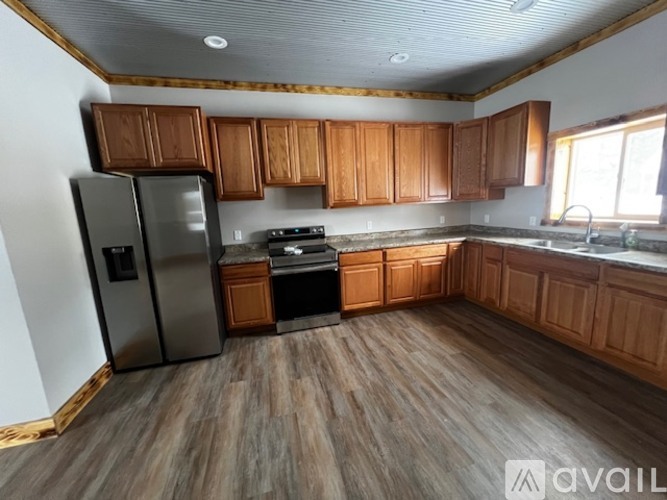 A kitchen with wooden cabinets and a stainless steel refrigerator.