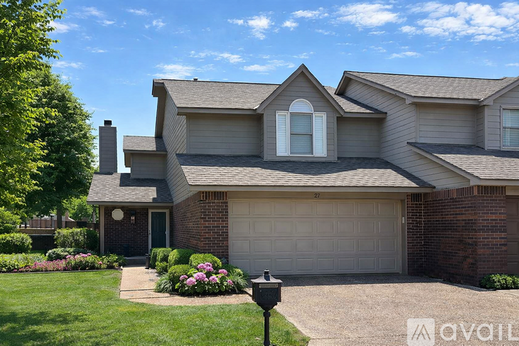A house with a grey garage door and a brick chimney.