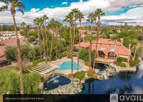 A beautiful view of a house surrounded by palm trees and a pool.