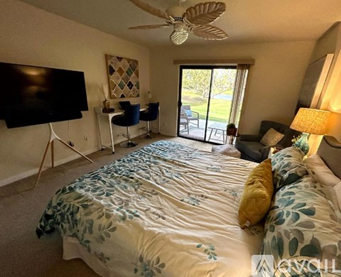A bedroom with a large bed and a flat screen TV.