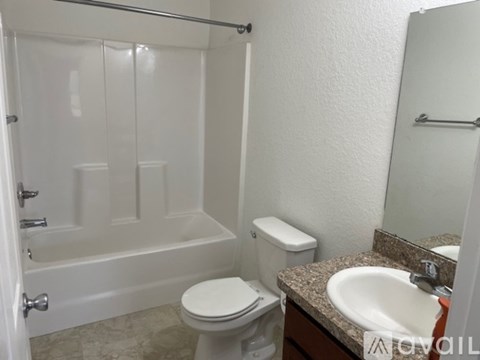 A white toilet sits next to a sink in a bathroom.