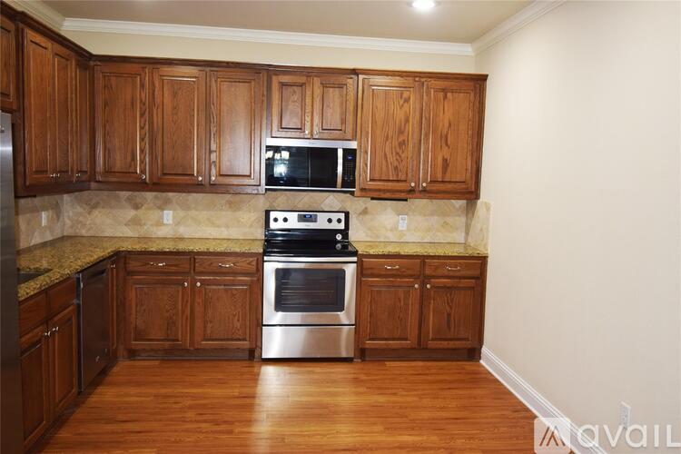 A kitchen with wooden cabinets and a stainless steel oven.