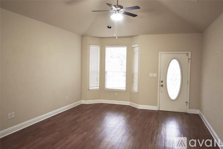 A room with wooden floors and a ceiling fan.