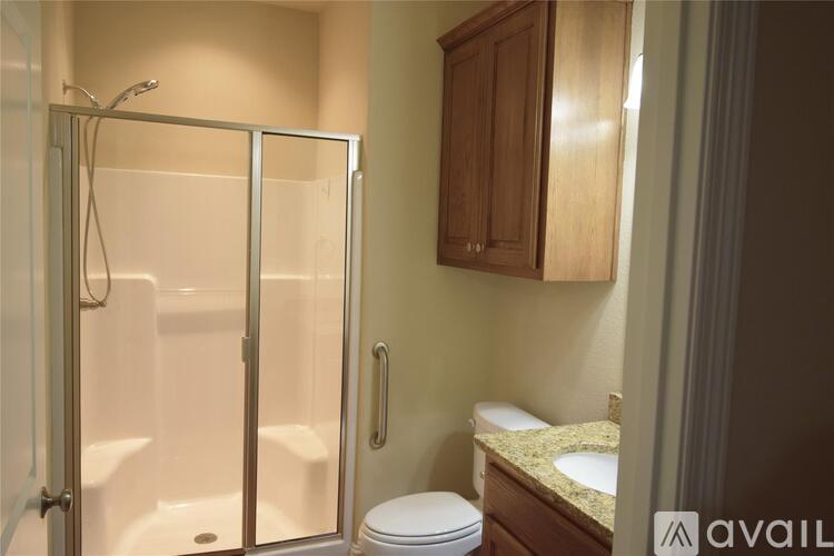 A bathroom with a walk in shower, toilet and sink.