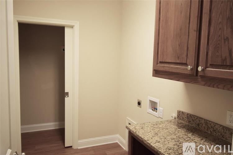A room with a marble countertop and wooden cabinets.