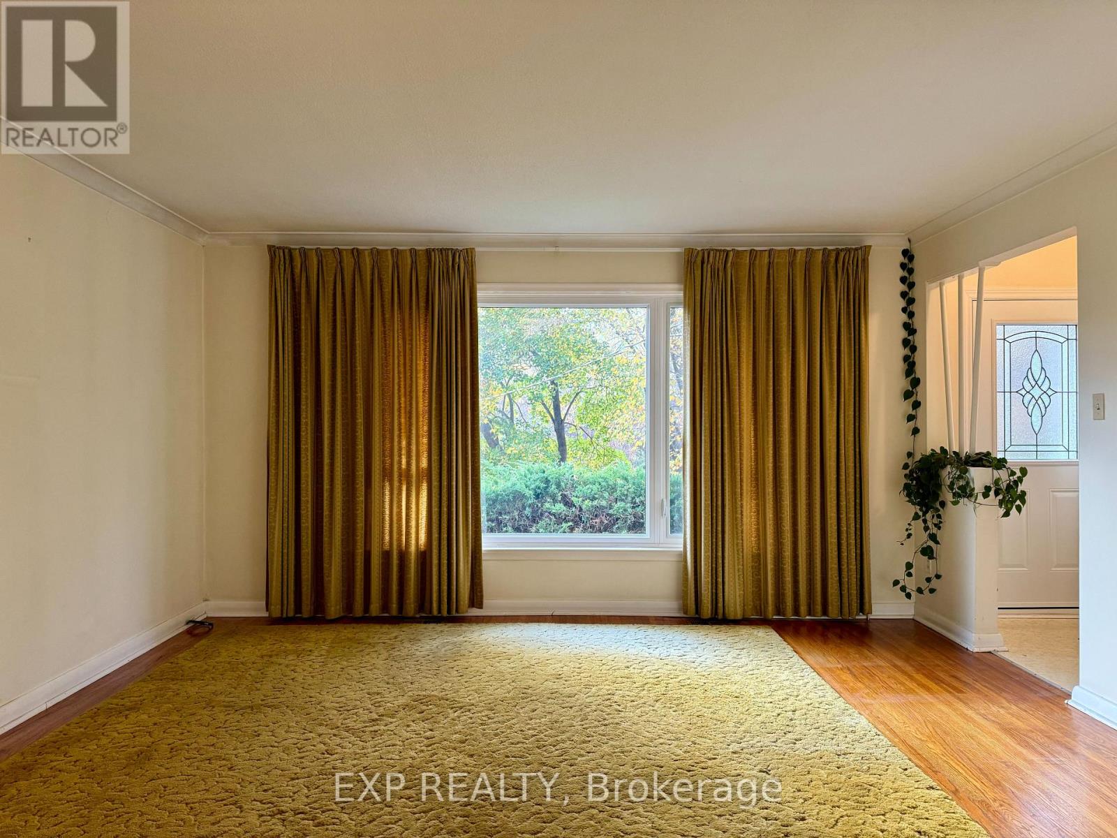 A room with a large window and curtains.