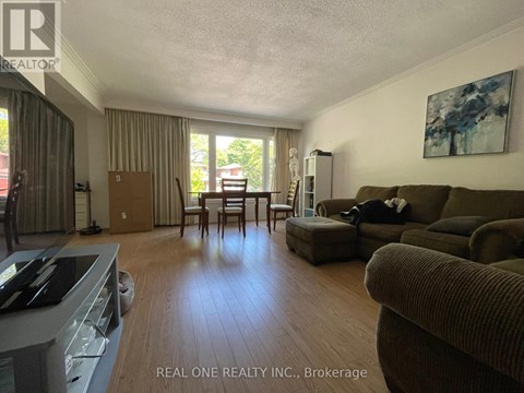 A living room with a couch, chair, and a painting on the wall.