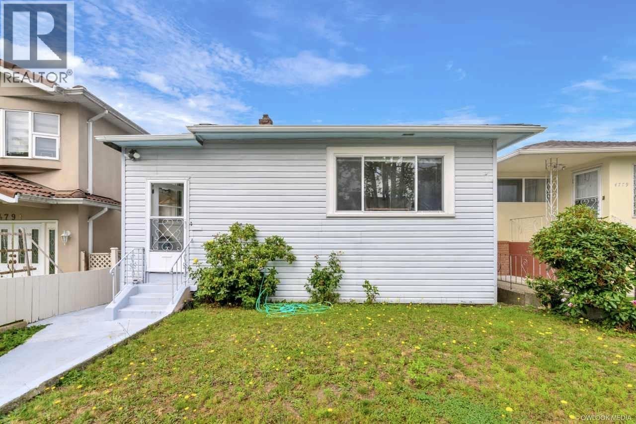 A house with a grey siding and a white door is for sale.