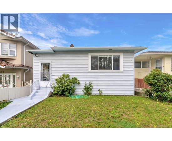 A house with a grey siding and a white door is for sale.