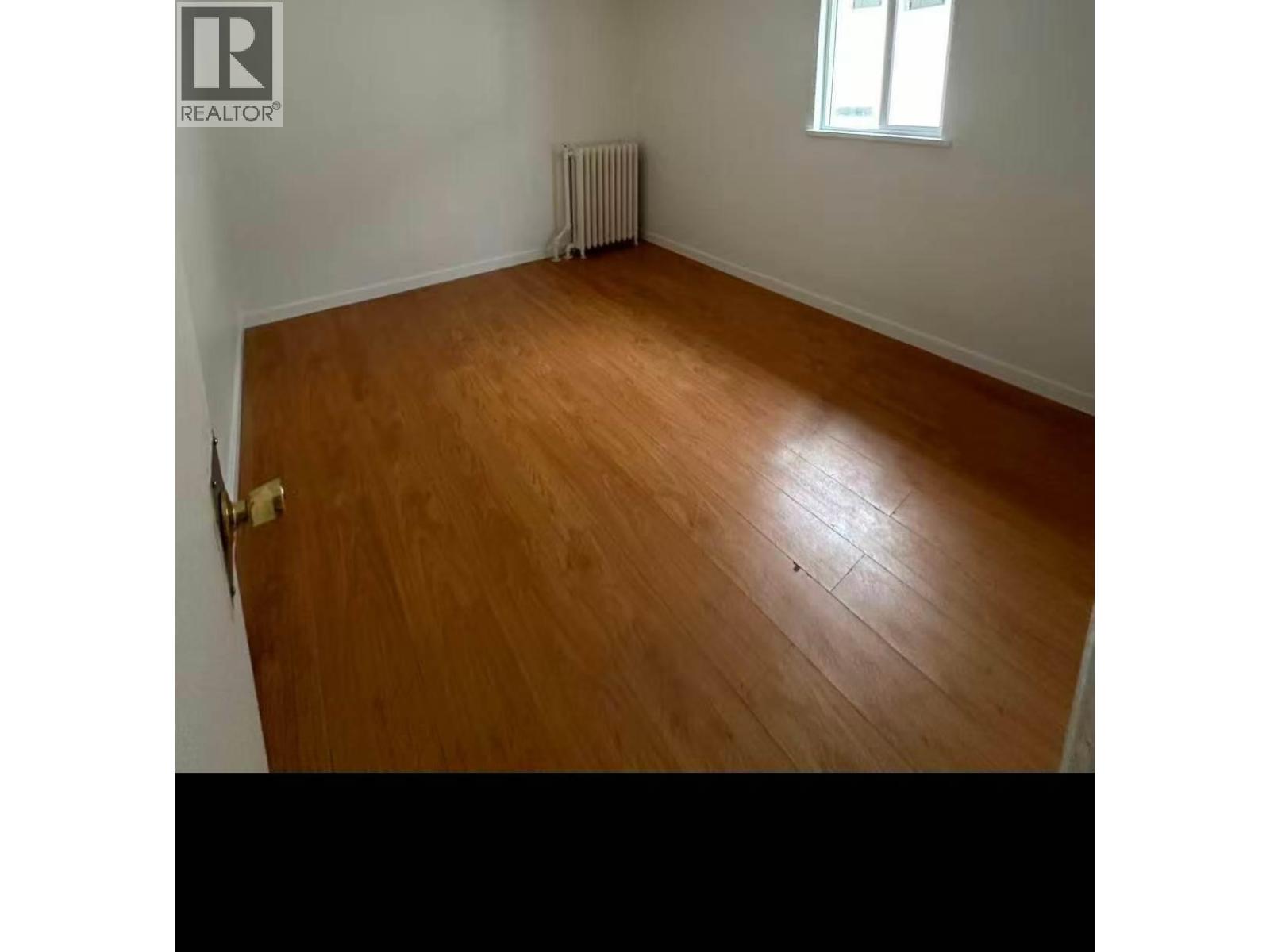 A room with wooden flooring and a window.