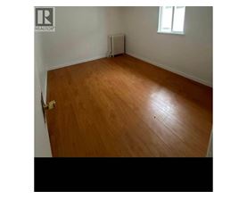 A room with wooden flooring and a window.