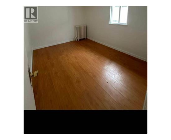 A room with wooden flooring and a window.