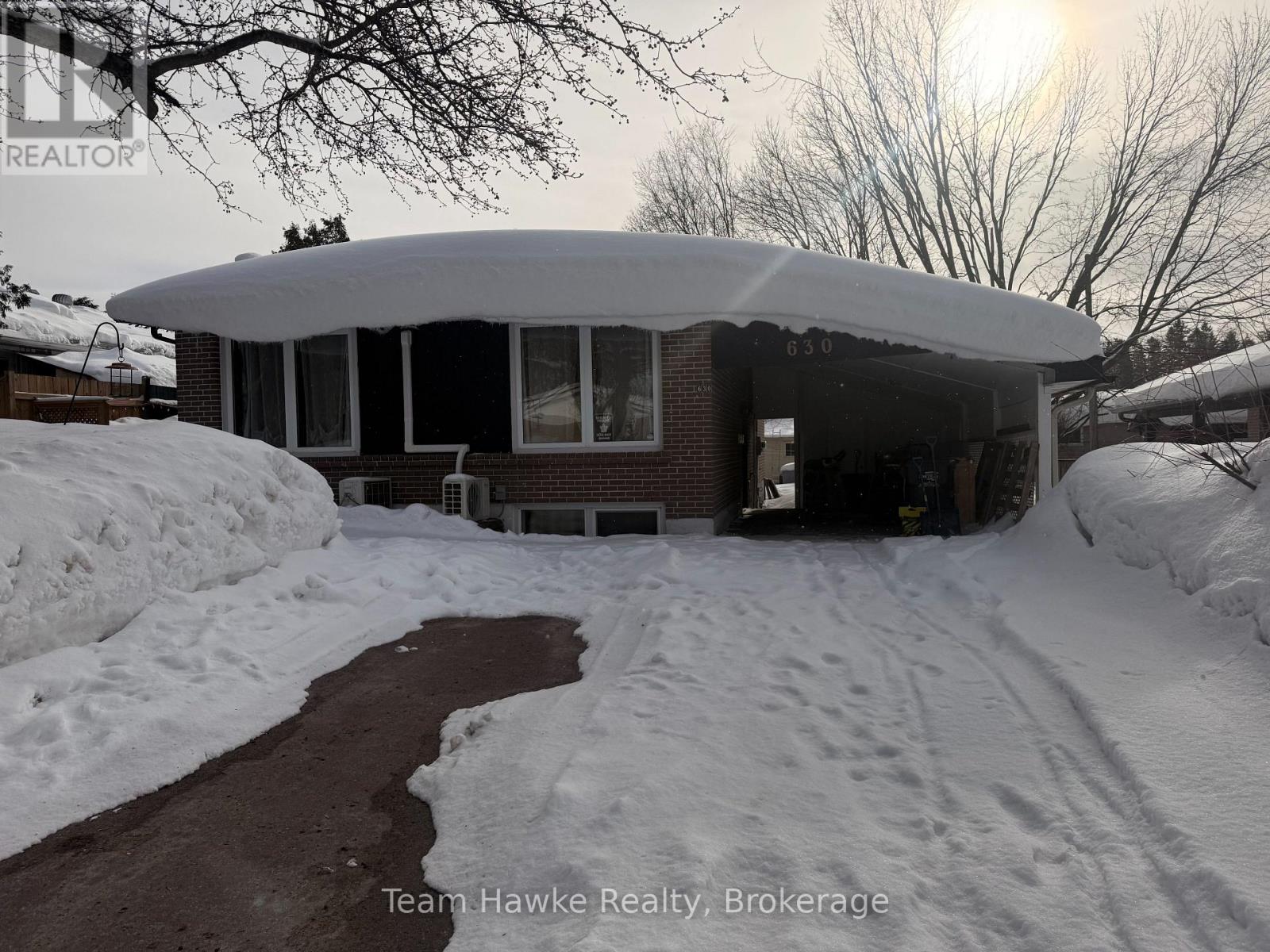 A house with a snow covered roof and driveway.