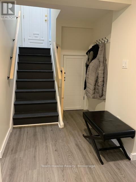 A hallway with a staircase and a bench.