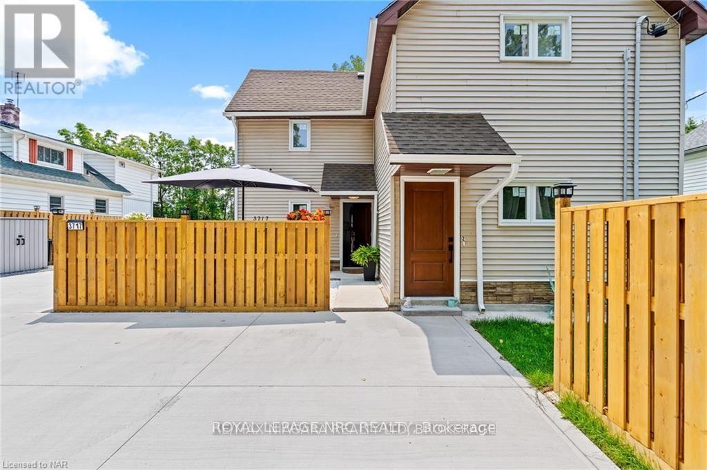 A house with a brown door and a wooden fence in front.