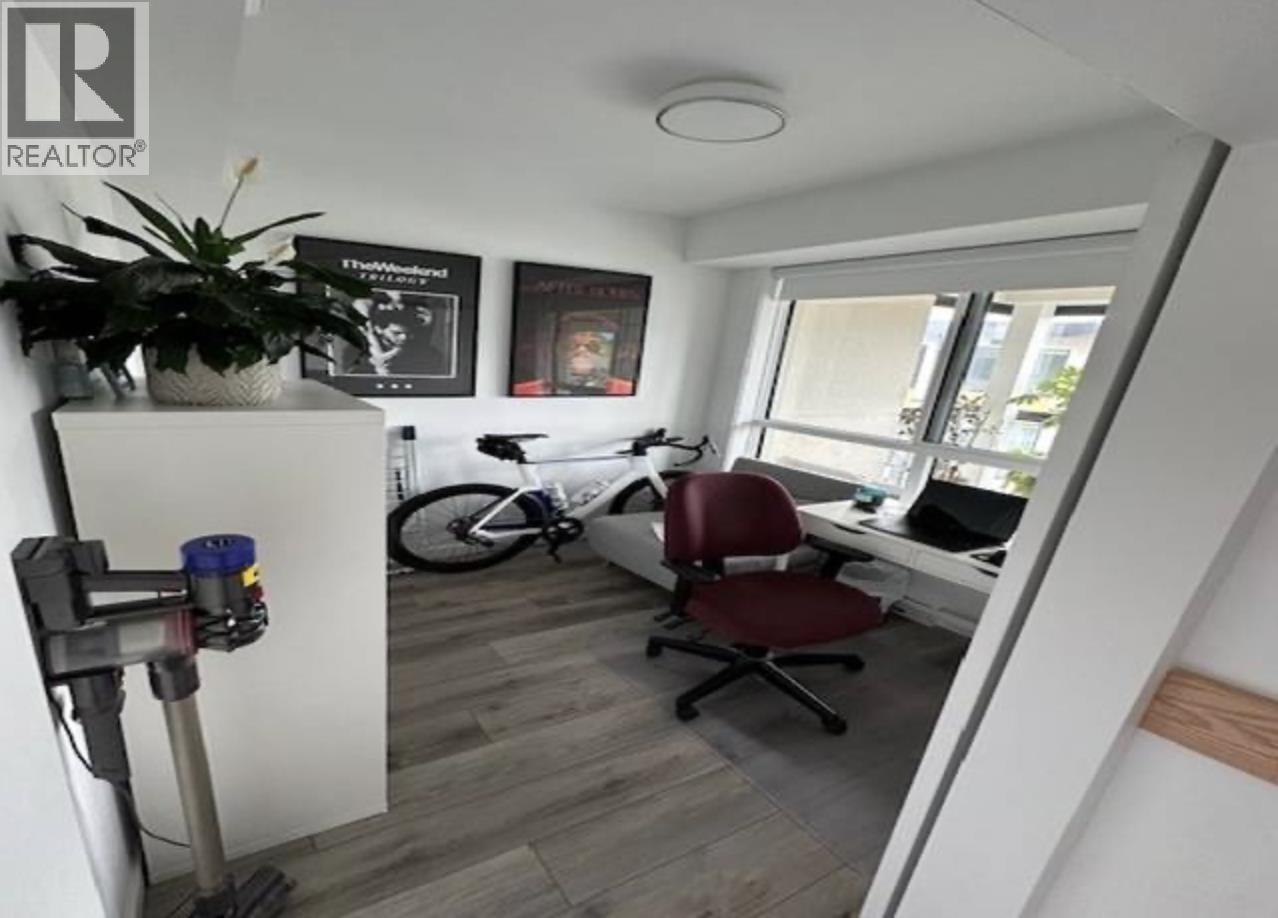 A room with a red chair and a bicycle in the background.