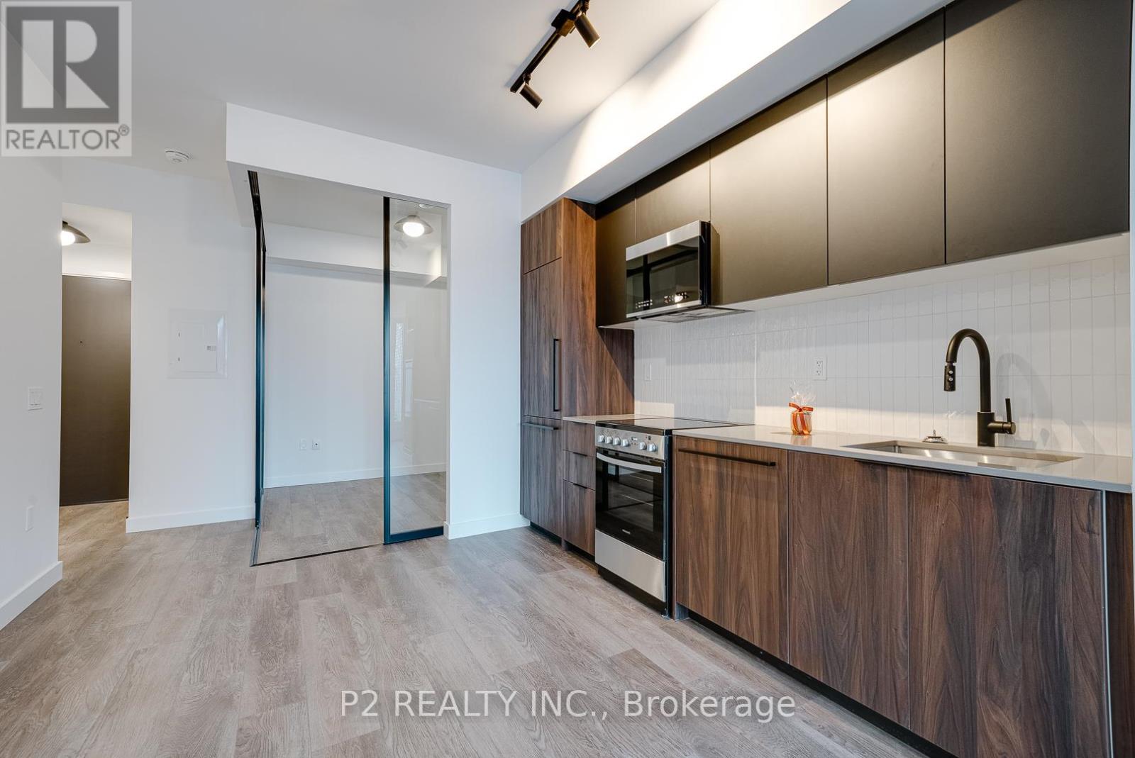 A modern kitchen with dark wood cabinets and a white countertop.