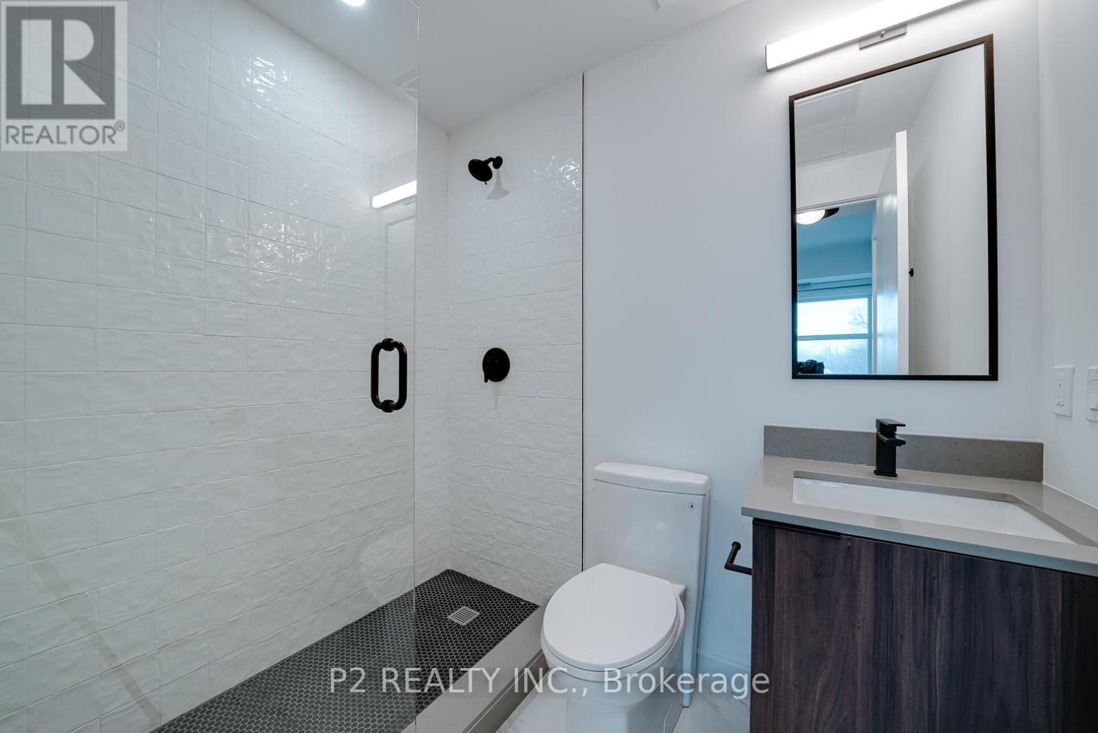A white bathroom with a toilet, sink, and mirror.