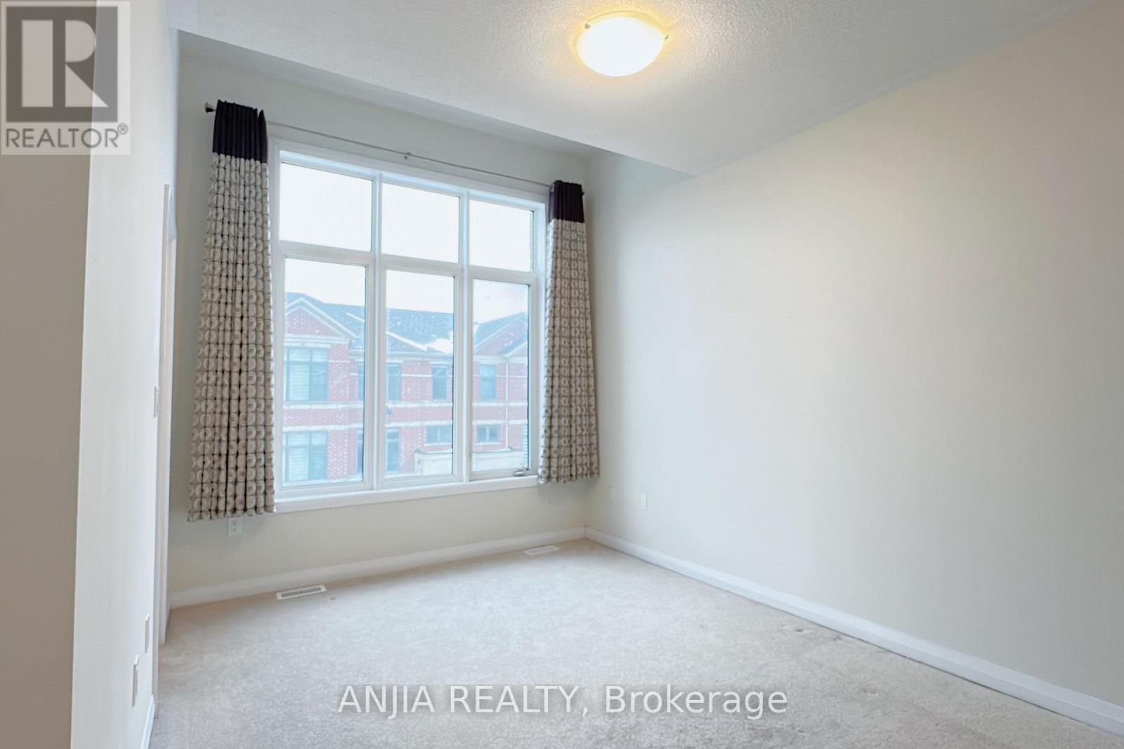 A room with a window showing a view of a building outside.