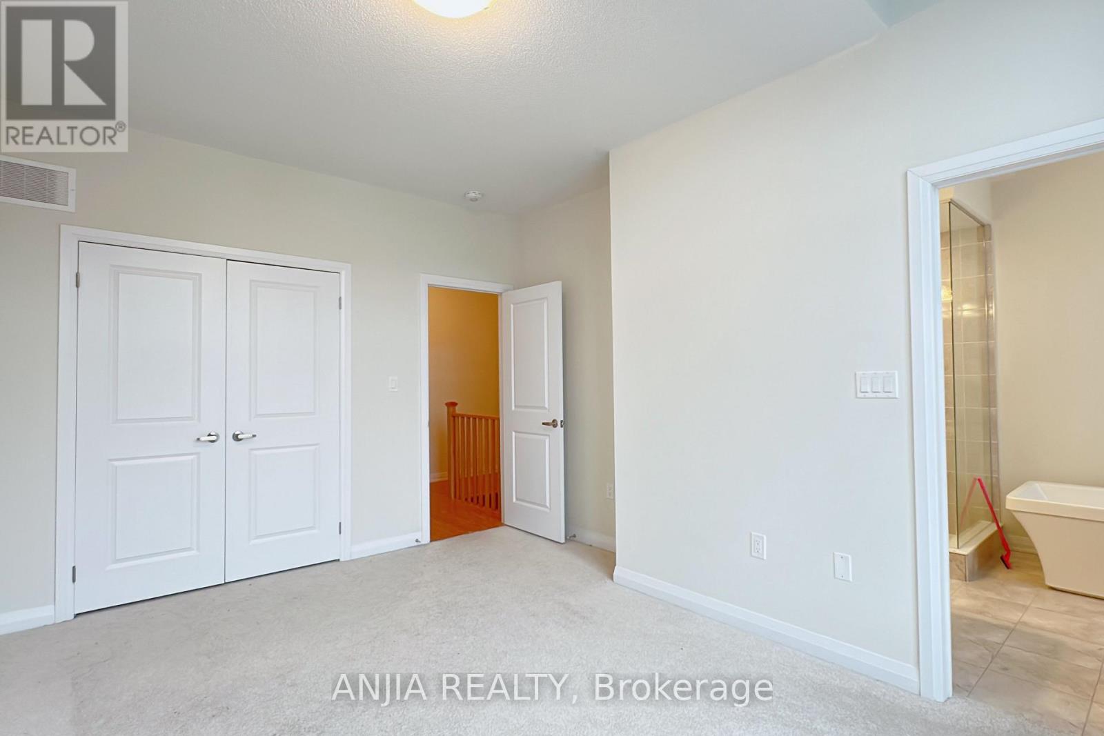 A realtor photo of a bedroom with a bathtub.