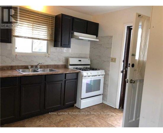 A kitchen with black cabinets and a white stove.