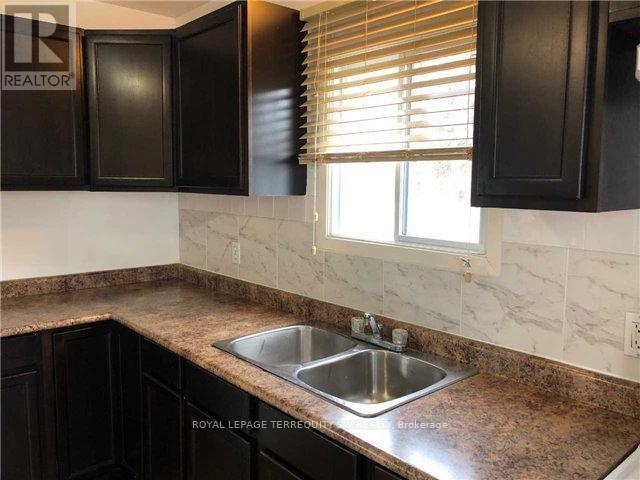 A kitchen with a sink and black cabinets.