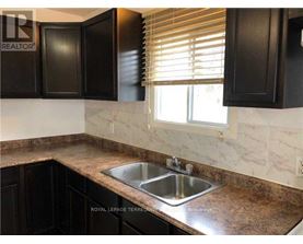 A kitchen with a sink and black cabinets.