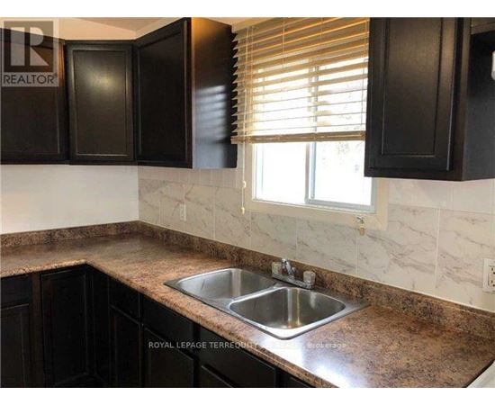 A kitchen with a sink and black cabinets.