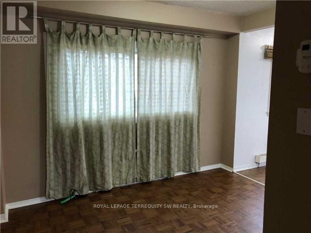A room with a curtain and a wooden floor.